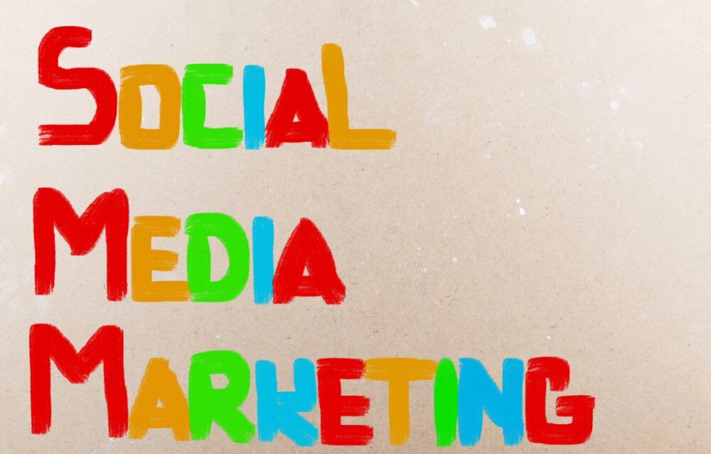 Vrolijke tekst ‘Social Media Marketing’ in felle kleuren op een beige achtergrond.